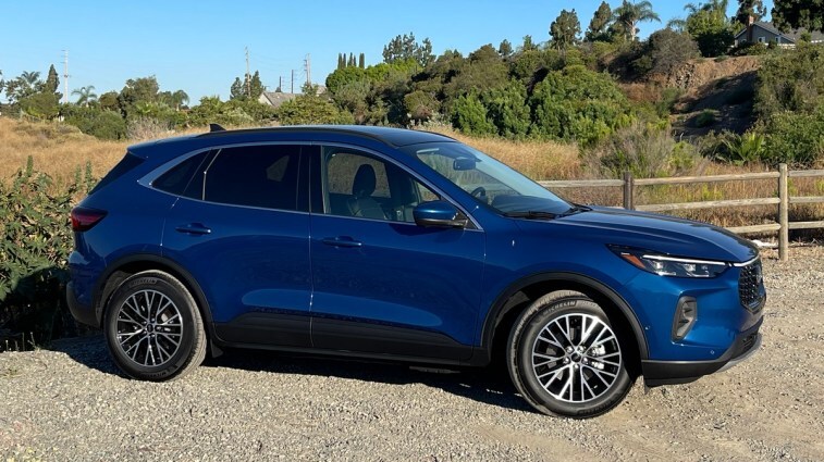 2023 Ford Escape PHEV in blue near wooden fence.