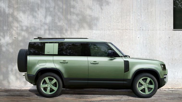 2023 Land Rover Defender 110 75th Edition in green next to a wall.
