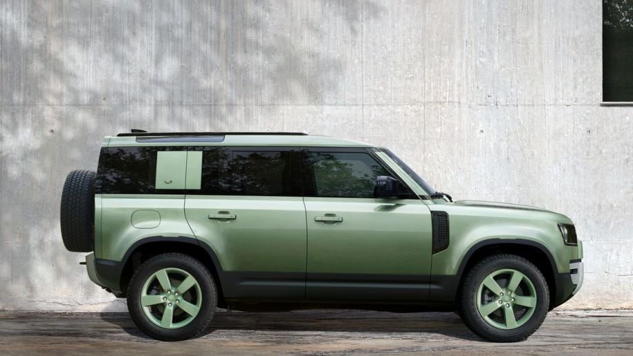 2023 Land Rover Defender 110 75th Edition in green next to a wall.