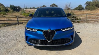 2024 Alfa Romeo Tonale in blue near a fence.