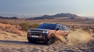 The 2024 Hyundai Santa Fe seen from a front quarter angle in sand