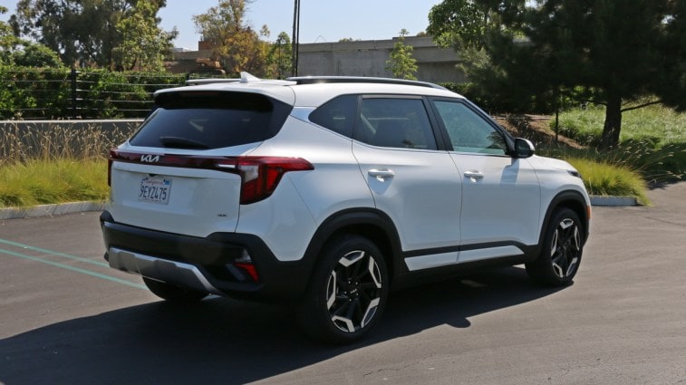 2024 Kia Seltos SX in white near grass and trees.