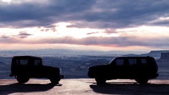 A teaser photo showing the silhouette of the 2024 Toyota Land Cruiser facing a classic Toyota BJ from the early 1950s