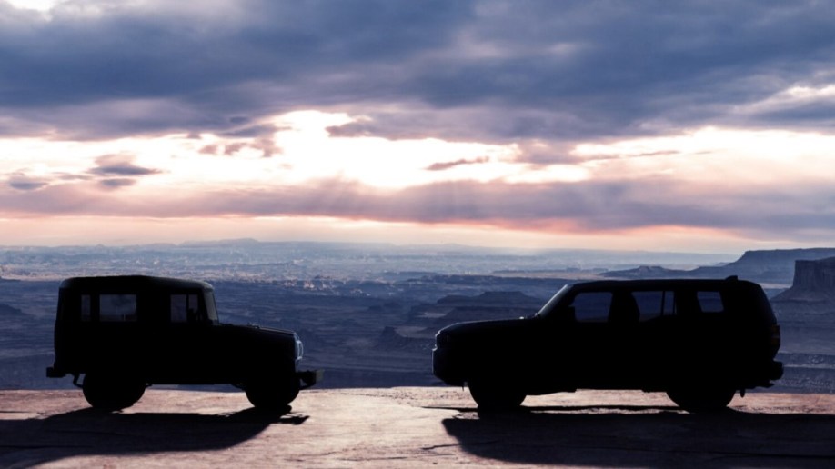 A teaser photo showing the silhouette of the 2024 Toyota Land Cruiser facing a classic Toyota BJ from the early 1950s