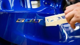 A closeup photo of the Chevy Bolt nameplate being applied in the factory