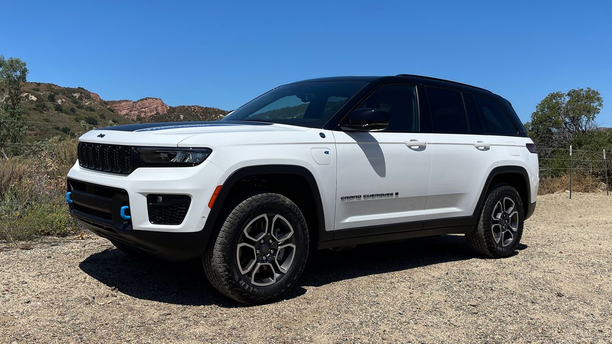 2023 Jeep Grand Cherokee Trailhawk 4xe in white with red hills in the background.