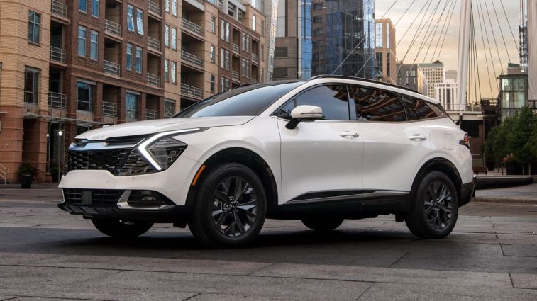 2024 Kia Sportage SX in white parked on a street.