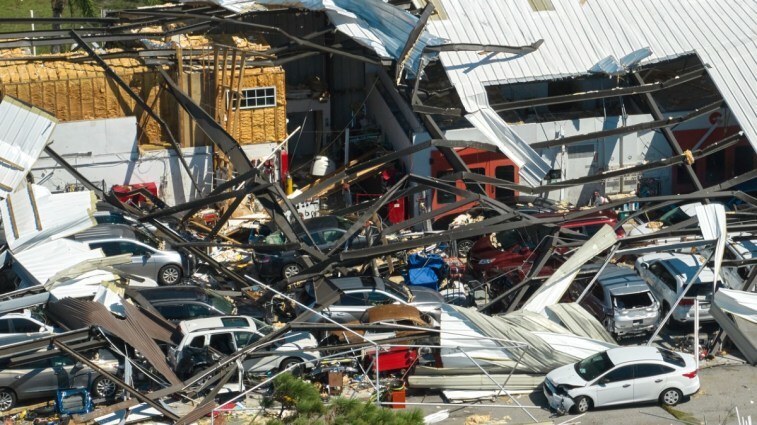 A building and cars damaged by hurricane