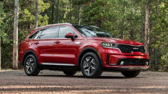 2023 Kia Sorento Hybrid in red in a forest.