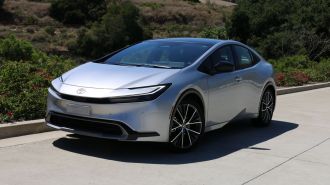 2023 Toyota Prius Limited in silver near bushes.