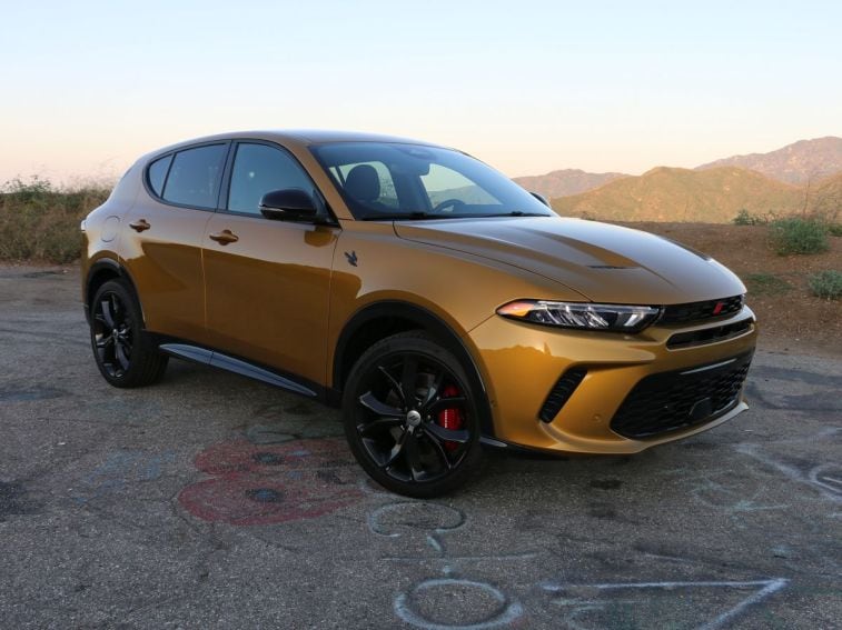 2024 Dodge Hornet RT PHEV in gold with hills in the background.