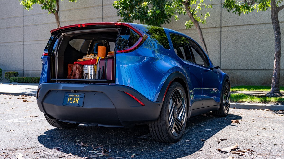 The 2024 Fisker Pear seen from a rear angle with its odd, drop-down tailgate