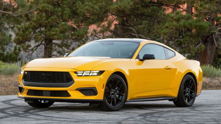 2024 Ford Mustang EcoBoost in yellow near pine trees.