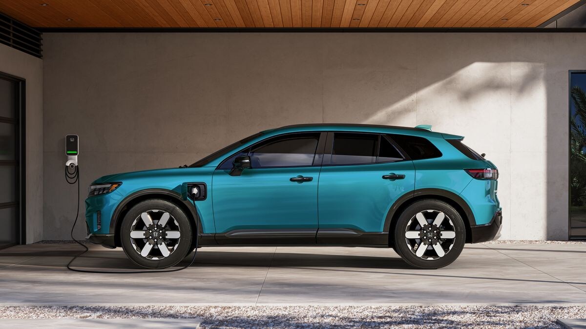 2024 Honda Prologue Elite in blue profile view charging in a carport.