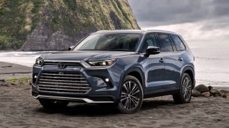 2024 Toyota Grand Highlander in blue parked on the beach.