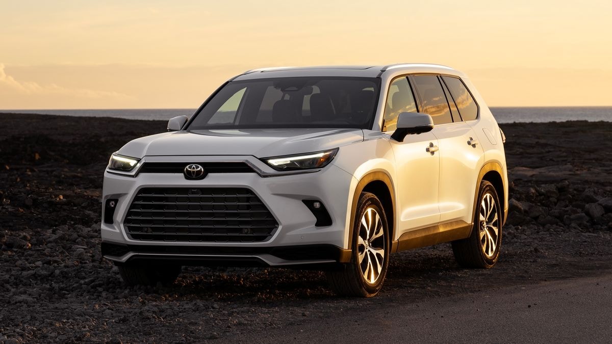 2024 Toyota Grand Highlander Hybrid in white at sunset.