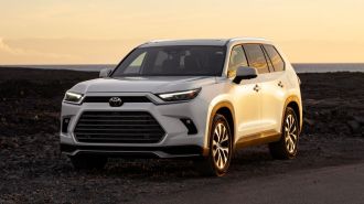 2024 Toyota Grand Highlander Hybrid in white at sunset.
