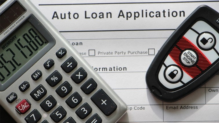 a calculator and car key on a auto loan application