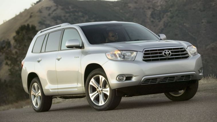 2010 Toyota Highlander in silver with hills in the background.