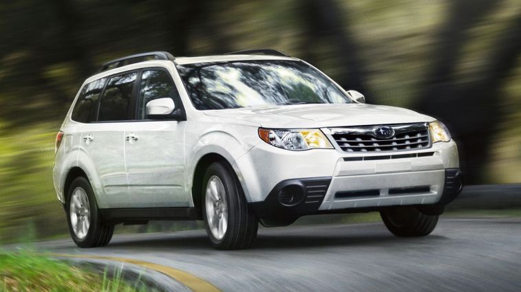 2012 Subaru Forester in white driving down a road.