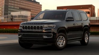2023 Jeep Wagoneer in black with buildings in the background.