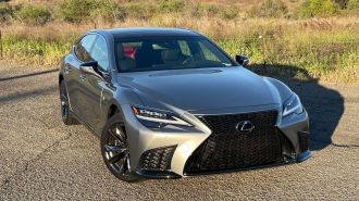 2023 Lexus LS 500 F Sport in silver near a grassy field.