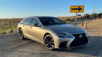 2023 Lexus LS 500 F Sport in silver near a directional sign.