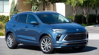 2024 Buick Encore GX Avenir with townhome in the background.