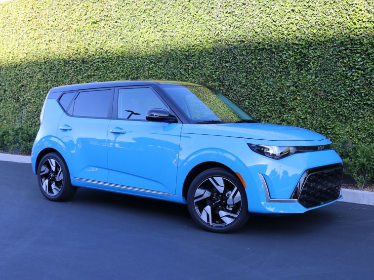 2024 Kia Soul GT Line in blue near an ivy green wall.