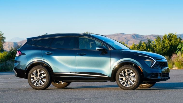 2024 Kia Sportage Hybrid in blue with hills in the background.
