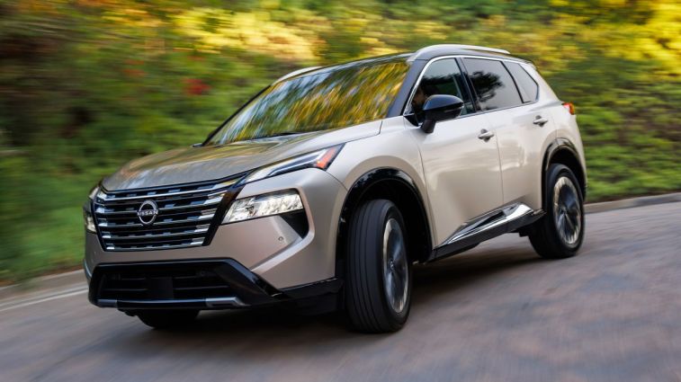 2024 Nissan Rogue driving down a driveway.