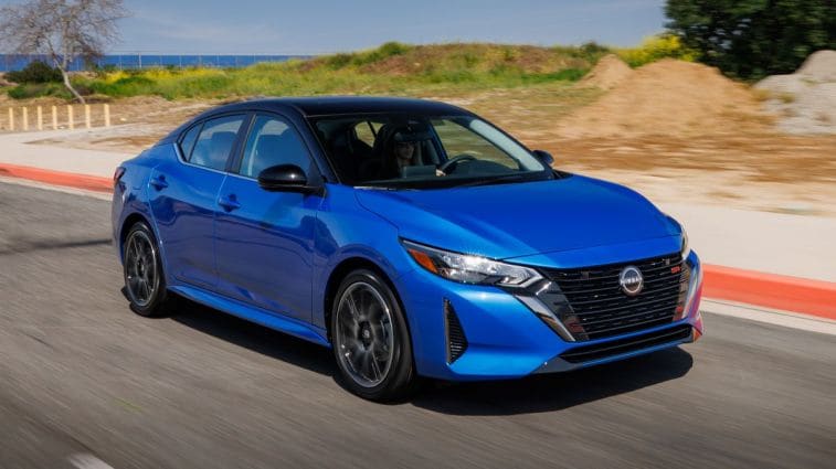 2024 Nissan Sentra in blue driving near the ocean.