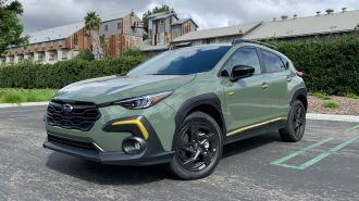 2024 Subaru Crosstrek Sport in green near bushes.