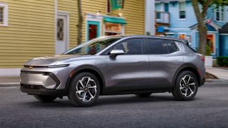 2024 Chevrolet Equinox EV 1LT in Galaxy Gray Metallic driving down a road.