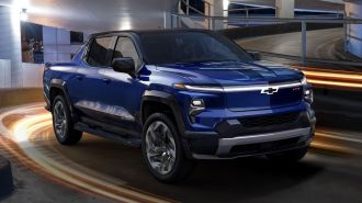 2024 Silverado EV RST in blue driving down a parking ramp.