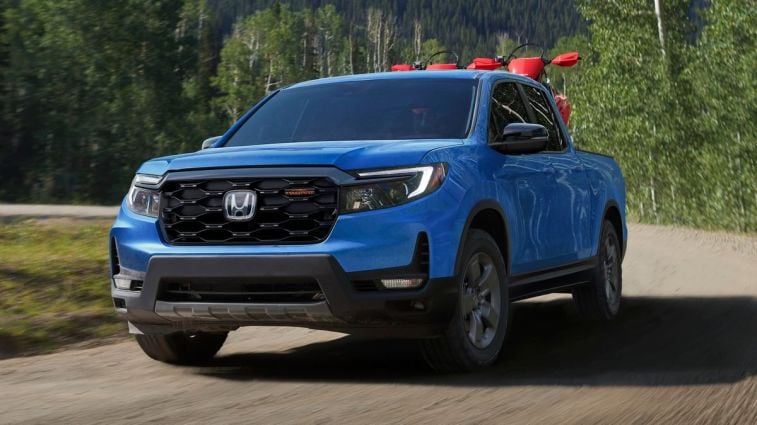 2024 Honda Ridgeline TrailSport in blue driving down a dirt road.