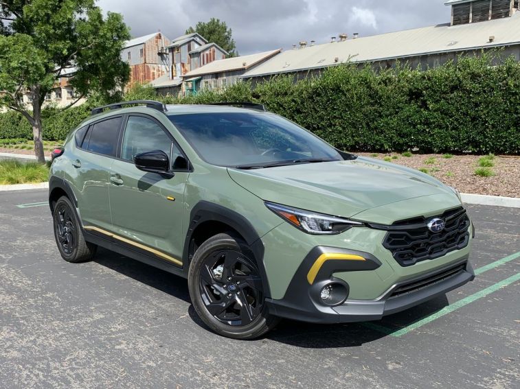2024 Subaru Crosstrek Sport in green with a metal barn in the background.