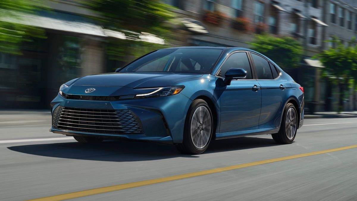 2025 Toyota Camry XSE in blue driving down a city street.