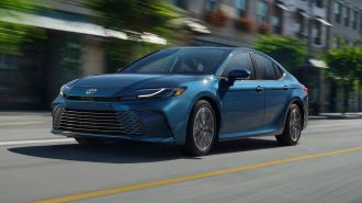 2025 Toyota Camry XSE in blue driving down a city street.