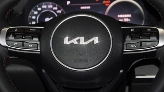 An aftermarket rhinestone Kia logo applied to a steering wheel as sold on Amazon