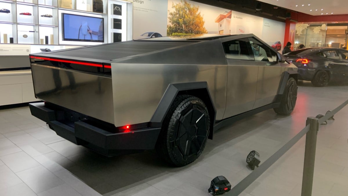 The Tesla Cybertruck seen from a rear quarter angle in a Tesla store