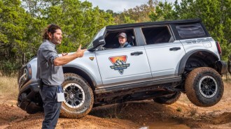 A participant in Ford's Bronco Off-Roadeo is coached through a maneuver