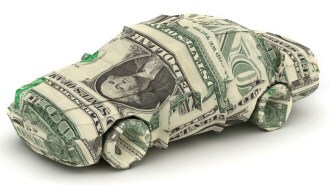 A toy car wrapped in dollar bills