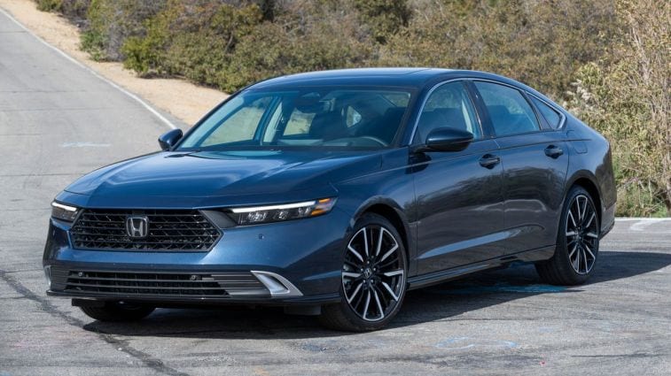 2024 Honda Accord Hybrid with bushes in the background.