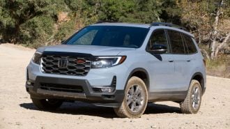 2024 Honda Passport TrailSport in grey on a dirt road.