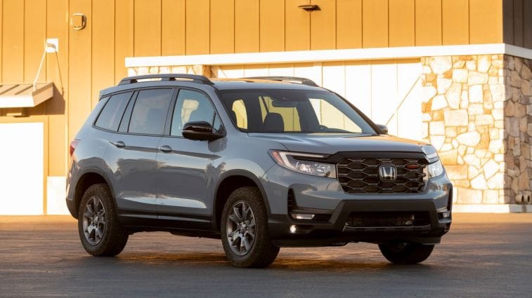 2024 Honda Passport TrailSport in grey parked near a barn.