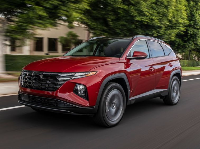 2024 Hyundai Tucson in red driving down a street.