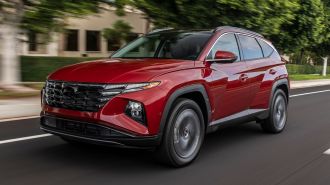 2024 Hyundai Tucson in red driving down a street.