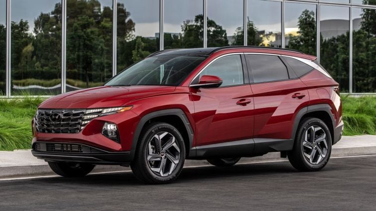 2024 Hyundai Tucson in red parked in front of a glass building.
