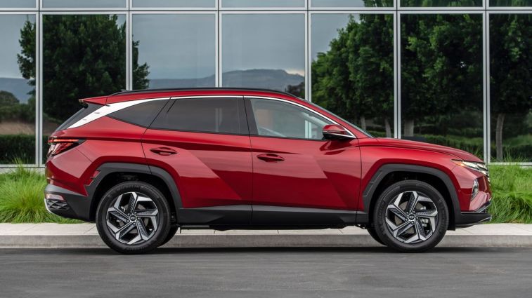 2024 Hyundai Tucson in red parked in front of a glass building.